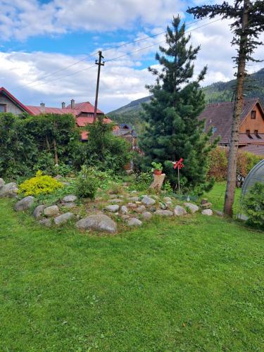 a rock garden in a yard with a tree at Penzion Havran in Ždiar