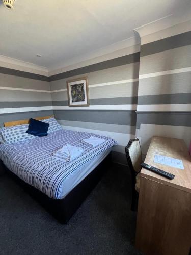 a bedroom with a bed and a desk with a computer at Boreland Lodge Hotel in Inverkeithing