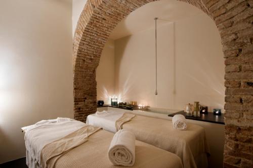 two massage beds in a room with a brick wall at Hotel Metropole Taormina in Taormina