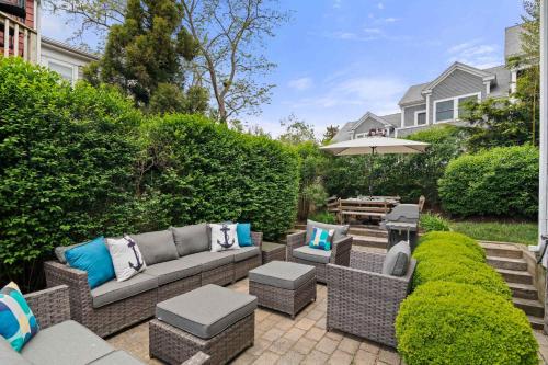 a patio with a couch and chairs and an umbrella at Private Home Great Location Dog Friendly in Provincetown