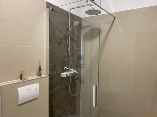 a bathroom with a shower with a glass door at GlamByAJ with free parking and Netflix in Pula