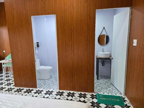 une salle de bain avec toilettes et miroir dans l'établissement MangoBungalow, à Hue