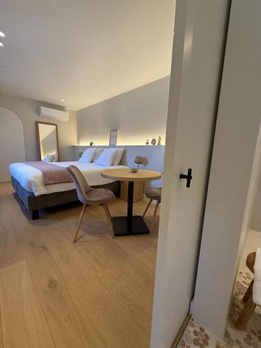 a bedroom with a bed and a table and chairs at Huyze Vinteling in Ypres