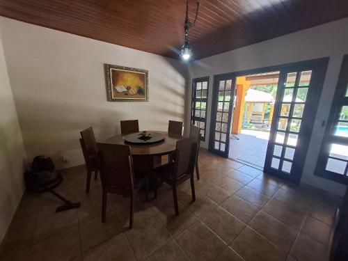 a dining room with a table and chairs in a room at Chácara com 05 dormitórios, piscina e Lazer LT0040 in Juquitiba