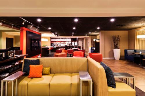 a lobby with a couch and chairs and a bar at Courtyard Mishawaka-University Area in South Bend