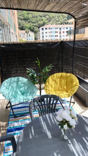 deux chaises et une table sur une terrasse dans l'établissement Appartement à Amelie-les-Bains-Palalda, à Amélie-les-Bains-Palalda