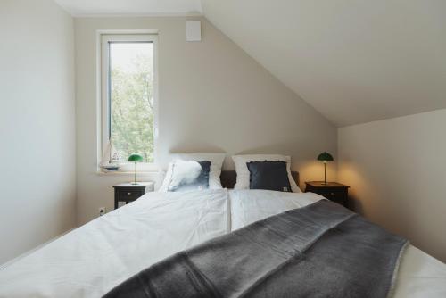 a bedroom with a large bed and a window at NEU "Rügen Resørt Sagard" großzügige, gemütliche Doppelhaushälfte "Niels" mit Terrasse in Sagard