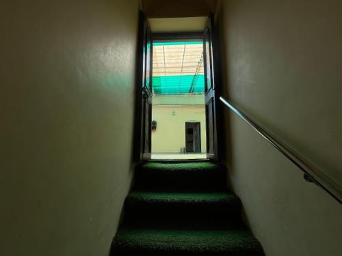 a stairway with green carpet and a window at Foreigners Inn in Varanasi