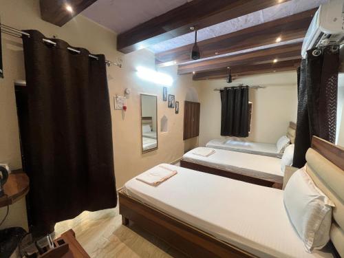 two beds in a room with black curtains at Foreigners Inn in Varanasi