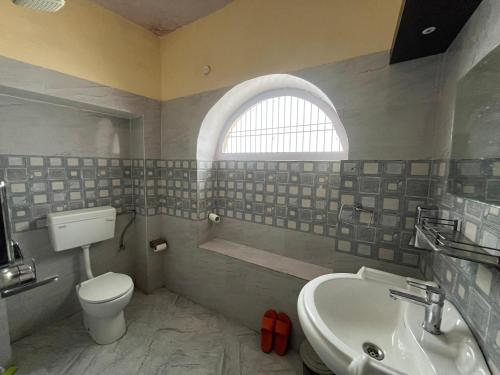 a bathroom with a toilet and a sink at Foreigners Inn in Varanasi