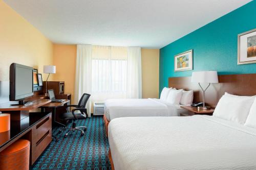 a hotel room with two beds and a television at Fairfield Inn & Suites Springfield in Springfield