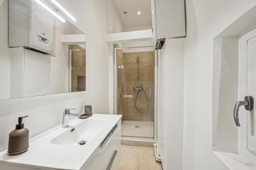 une salle de bain blanche avec un lavabo et une douche dans l'établissement Magnifique appartement - Croix Rousse, à Lyon