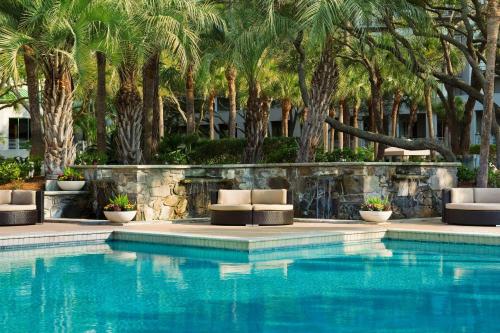 a swimming pool with lounge chairs and palm trees at The Westin Hilton Head Island Resort & Spa in Hilton Head Island