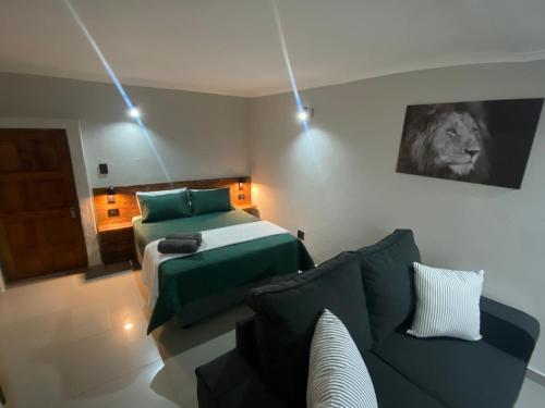 un soggiorno con divano e letto di The Hideaway a Nelspruit