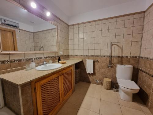 a bathroom with a sink and a toilet and a mirror at Agroturismo Sa Marina - Adults Only in Cala Boix