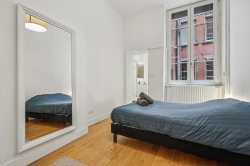 une chambre avec un lit et un grand miroir dans l'établissement Magnifique appartement - Croix Rousse, à Lyon