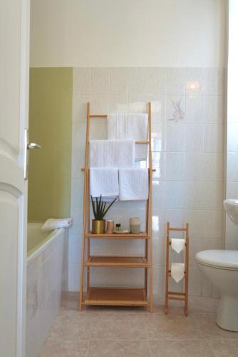 a bathroom with a towel rack with a toilet and a sink at HÖTEL U SANTA MARIA in Olmeto