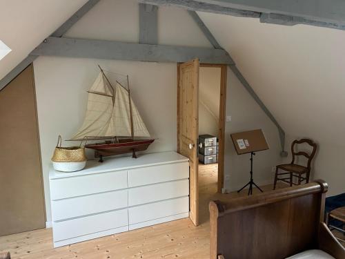 a room with a sail boat on a wall at Maison de charme in Pluneret