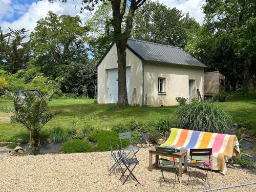 a house with a garden with a bench and a table at Maison de charme in Pluneret