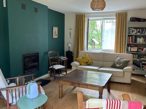 a living room with a couch and a table at Maison de charme in Pluneret