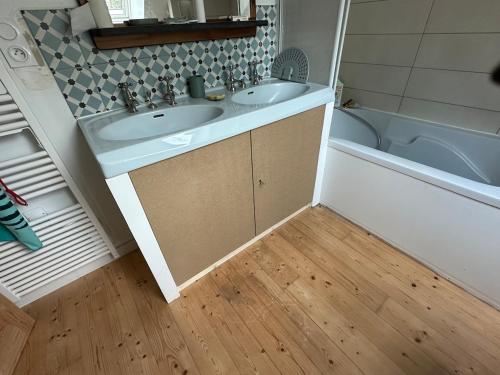 a bathroom with a sink and a bath tub at Maison de charme in Pluneret