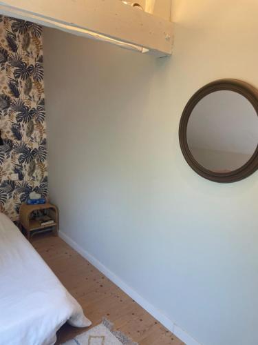 a bedroom with a mirror on the wall at Maison de charme in Pluneret