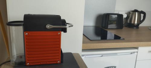 un objet noir et rouge dans une cuisine dans l'établissement Le Jardin des Nosières, Gîte proche du Puy du Fou, à Le Boupère