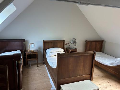 a bedroom with two beds and a desk with a lamp at Maison de charme in Pluneret