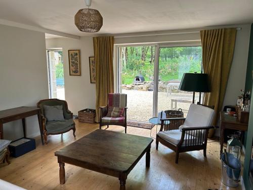 a living room with a coffee table and chairs at Maison de charme in Pluneret