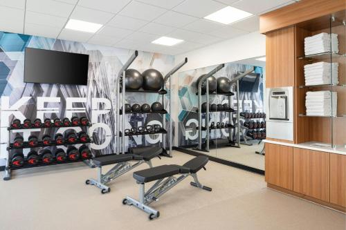 a gym with dumbbells and a flat screen tv at SpringHill Suites by Marriott Raleigh Garner in Garner