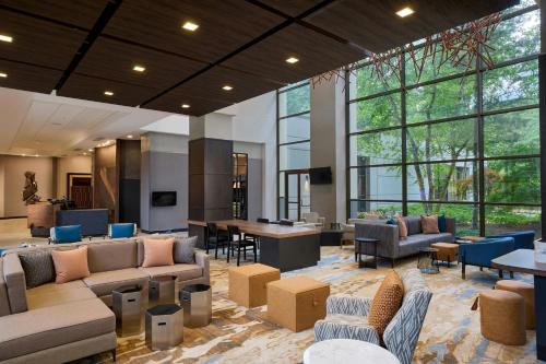 a large lobby with couches and tables and windows at Pittsburgh Airport Marriott in Robinson Township