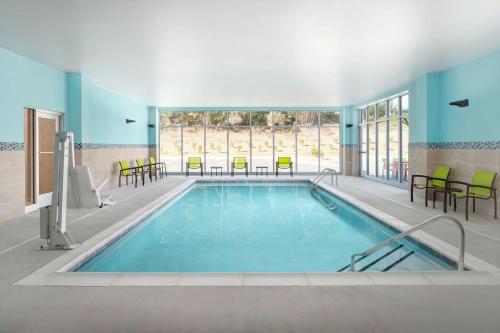 a pool in a building with chairs and tables at SpringHill Suites by Marriott Raleigh Garner in Garner