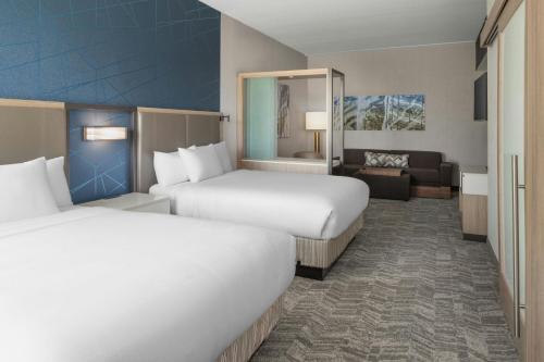 ein Hotelzimmer mit zwei Betten und einer Couch in der Unterkunft SpringHill Suites by Marriott Raleigh Garner in Garner