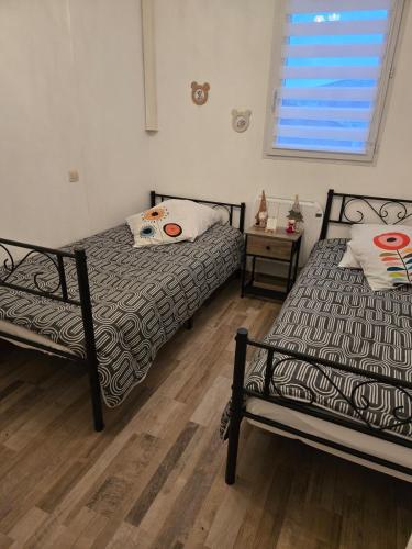 - une chambre avec 2 lits et une table avec une fenêtre dans l'établissement Lili Berges du Canal, à Béziers