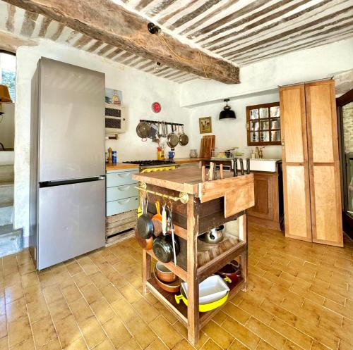 a kitchen with a refrigerator and a counter with pots and pans at La Mistraline, 2 bedrm 2 bath house in the heart of Provence in Caseneuve