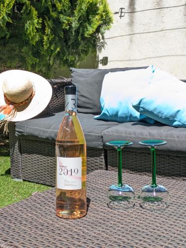 - une bouteille de vin assise sur une table avec deux tabourets dans l'établissement GRAND T2 lumineux avec JARDIN PRIVE, à Trets