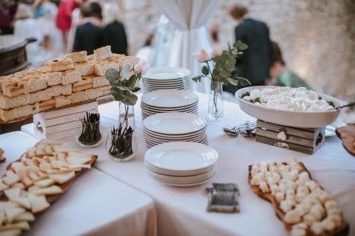a table with white plates and a buffet of food at Relais La Costa Historical Residence in Monteriggioni