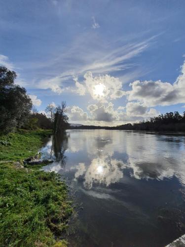 a river with the sun reflecting in the water at Alvorada Medieval, AL in Valença