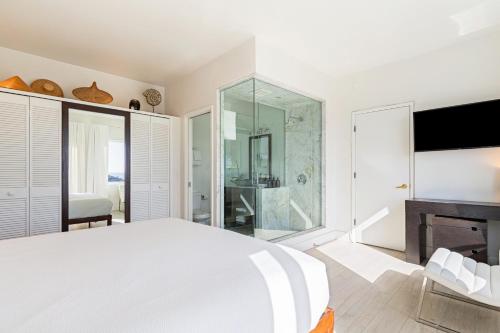 a bedroom with a large bed and a glass shower at The Cayucan Bungalows by AvantStay Pet-Friendly Getaway Steps from Cayucos State Beach in Cayucos