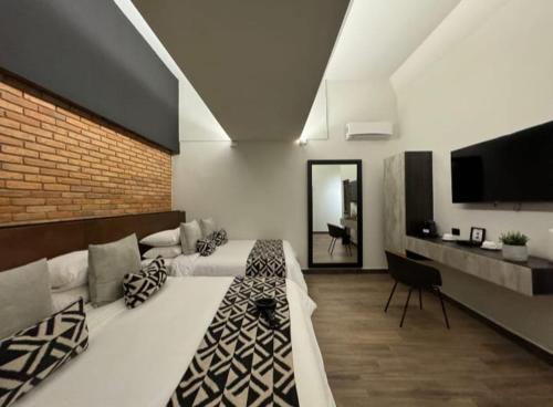 a large room with two beds and a television at Esplendor by Wyndham San Luis Potosi in San Luis Potosí