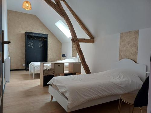 a bedroom with two beds and a desk and a window at Gîte Côté Val in Montlivault