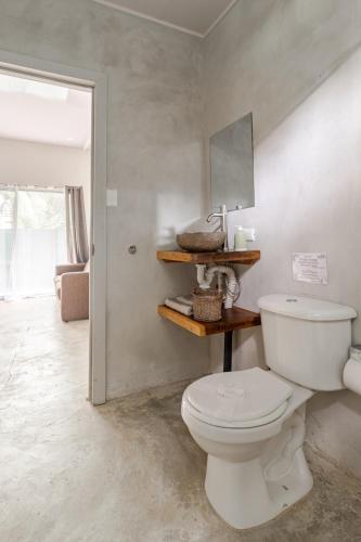a bathroom with a white toilet in a room at Casa Yute in Talamanca