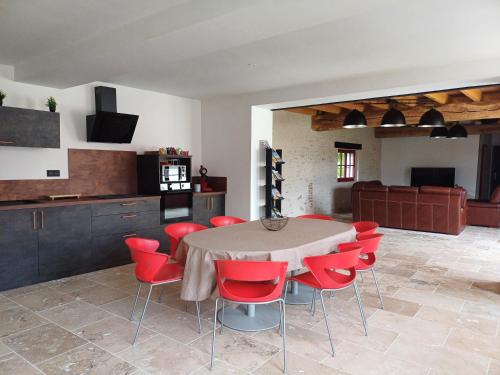 une salle à manger avec une table et des chaises rouges dans l'établissement Gîte Côté Val, à Montlivault