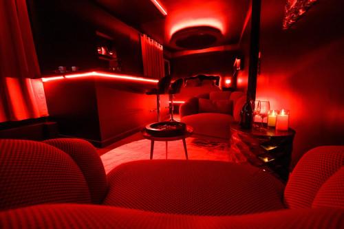 une chambre rouge avec des chaises rouges et une table dans l'établissement Suite Romantic - Love room - Toulouse centre, à Toulouse