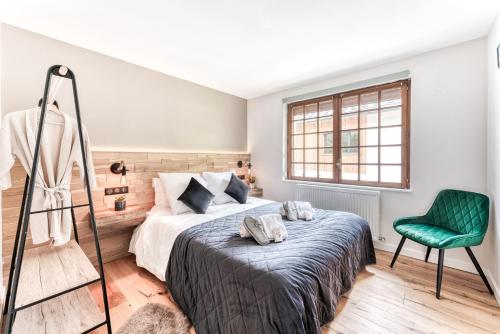 - une chambre avec un lit et une chaise verte dans l'établissement Appartement de Luxe avec Jacuzzi, Vue Montagne et Jardin, à Chamonix-Mont-Blanc