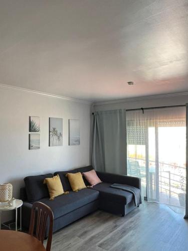 a living room with a blue couch with yellow pillows at Bibel Ocean Home Sunset by the sea in Vila Praia de Âncora