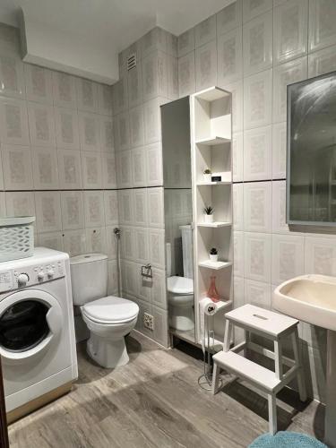a bathroom with a toilet a sink and a washing machine at Bibel Ocean Home Sunset by the sea in Vila Praia de Âncora