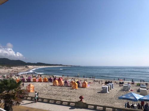 a beach with people and umbrellas and the ocean at Bibel Ocean Home Sunset by the sea in Vila Praia de Âncora