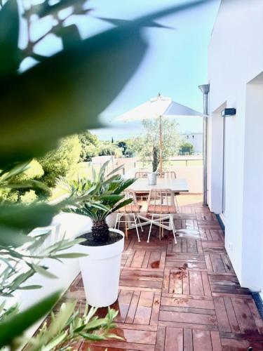 un patio avec une table, des chaises et un parasol dans l'établissement Appartement de charme, à La Ciotat