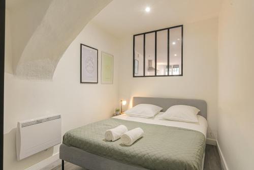 ein Schlafzimmer mit einem Bett mit zwei weißen Kissen in der Unterkunft Le Siméon - T2 plein pied, cosy, au cœur de la zone piétonne in Vienne